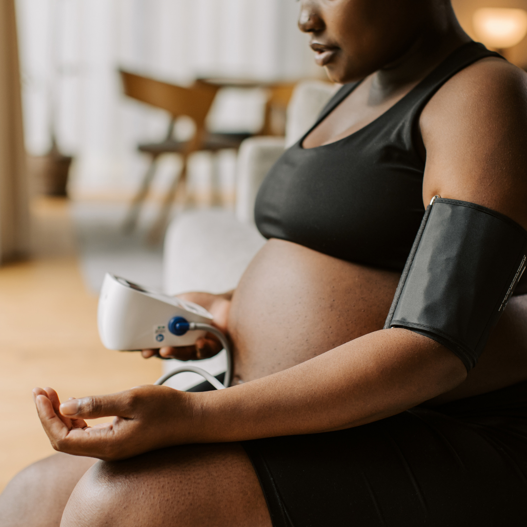 Pregnant woman checking her blood pressure at home