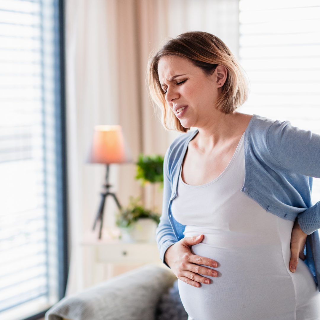 Pregnant woman experiencing abdominal discomfort while receiving support