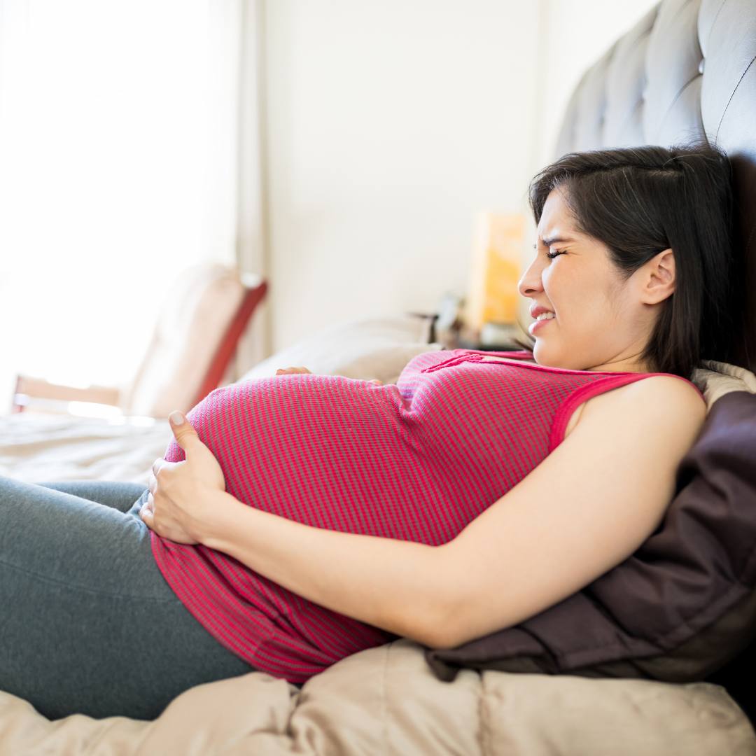 Pregnant woman resting while experiencing abdominal tightening